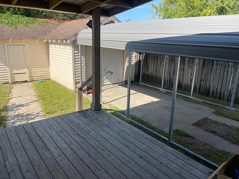 Backyard, outdoor garage and covered parking with a gate.