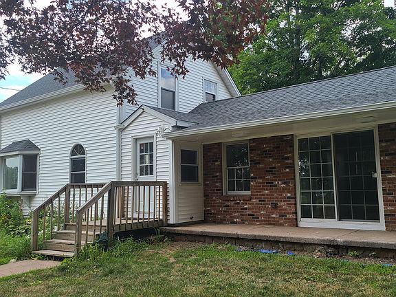 Main entrance from the South side of the house near the parking area and driveway.