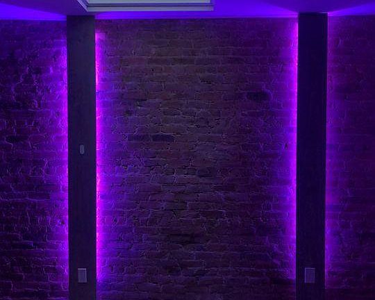 Rustic living room with 100 year old refurbished exposed brick wall and skylight. Includes sound-reactive LED lights, various light color options.