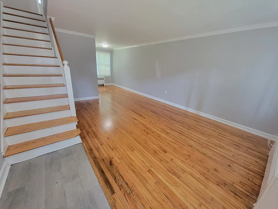 Living and Dining room combo with gleaming hardwood floors.