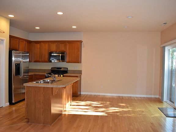 Stainless steel appliances, gas stove, pantry closet next to refrigerator