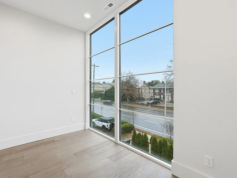 Bright bedroom with large windows, natural light, and modern finishes.