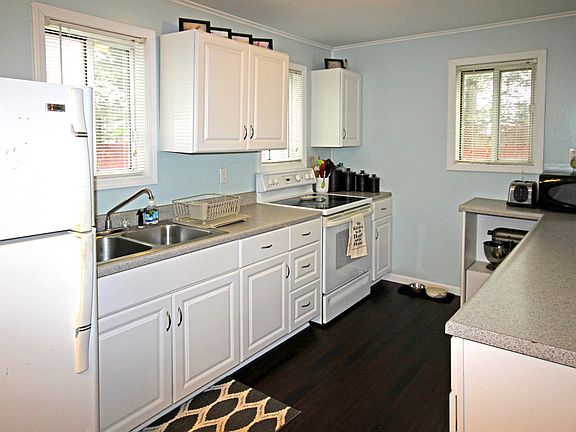 Freshly painted kitchen makes the newer white cabinetry pop while while the grey counter tops coordinate well. The whole home has been freshly painted in neutral and stylish colors. A window over the kitchen sink looking at the countryside is a plus!