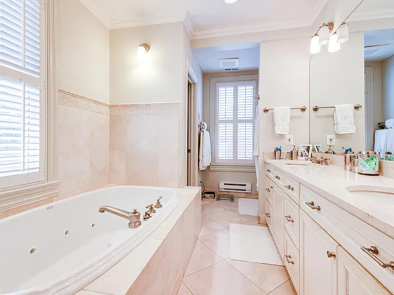 Master bathroom with double sinks, soaking tub, glass shower, and separate toilet room.