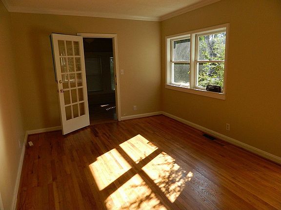 Living room with French door leading to private office area with built-in storage shelves