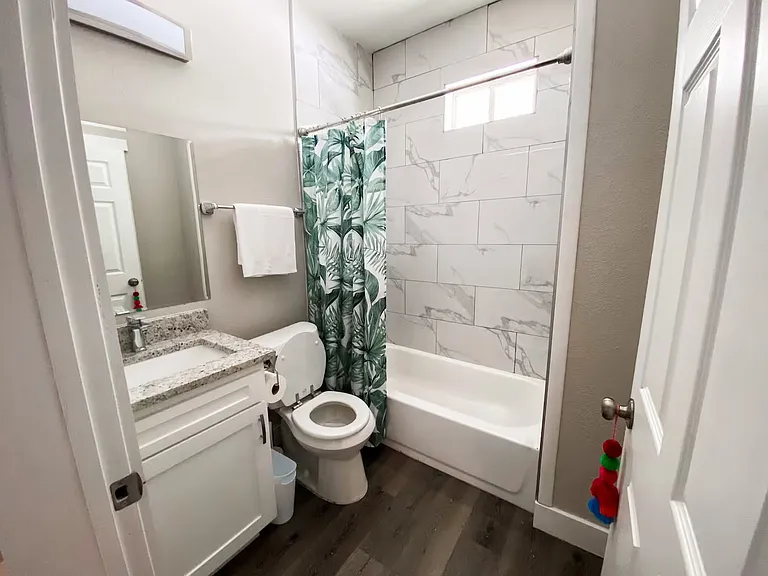 Well-appointed bathroom featuring a tiled shower, granite vanity, linen closet, and plenty of space for everyday comfort.