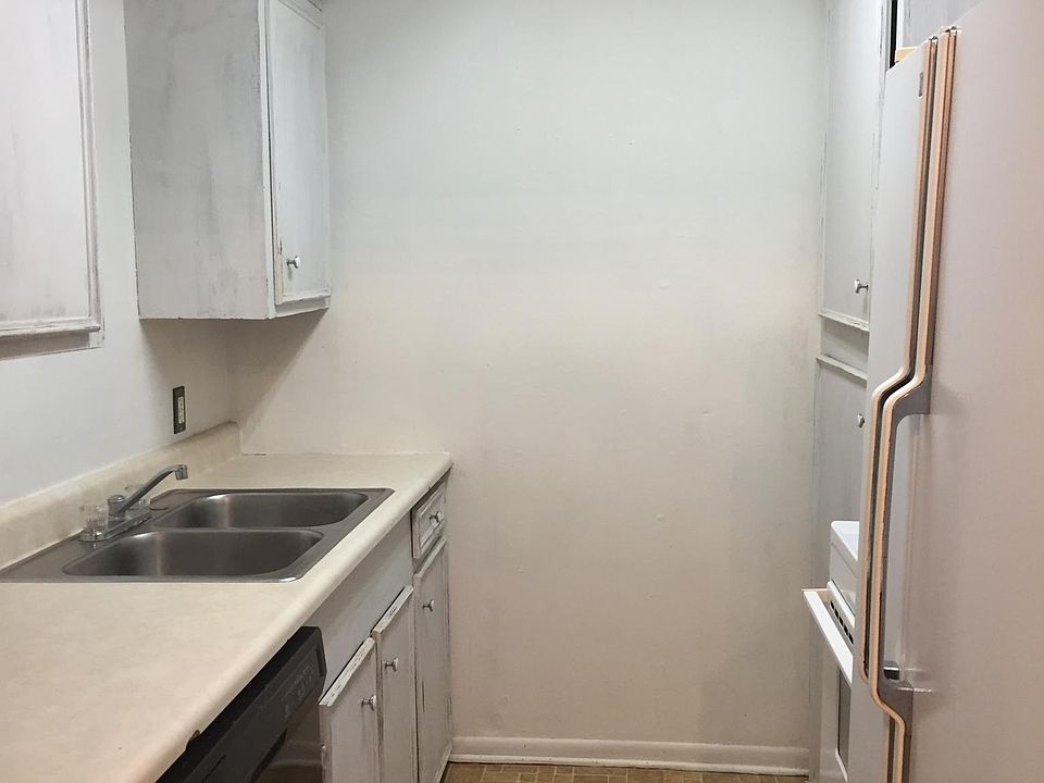 Kitchen with white cabinets, dishwasher, fridge & range/oven.