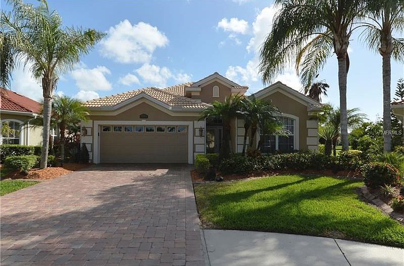 Front of house with mature landscaping  & custom paver drive/walkway.