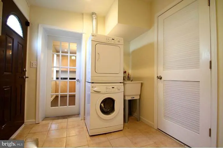 1st Floor: View of laundry room looking toward front of house. Doorway to private alley on left and door to HVAC room on right.