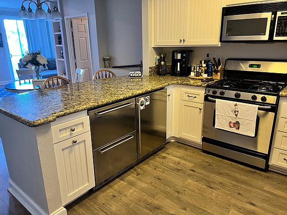 kitchen countertop with fridge and freezer beneath, a second refrigerator is downstairs in the garage