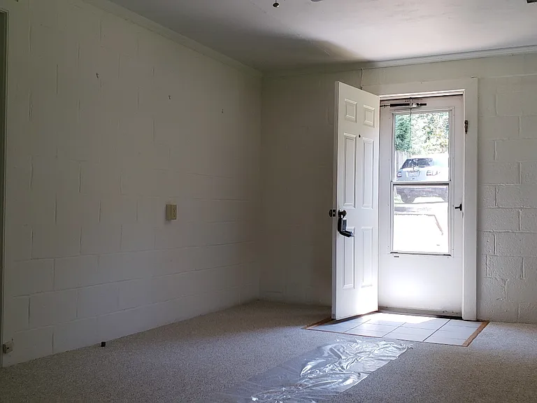 A 2nd view of the living room, looking at the entry door.