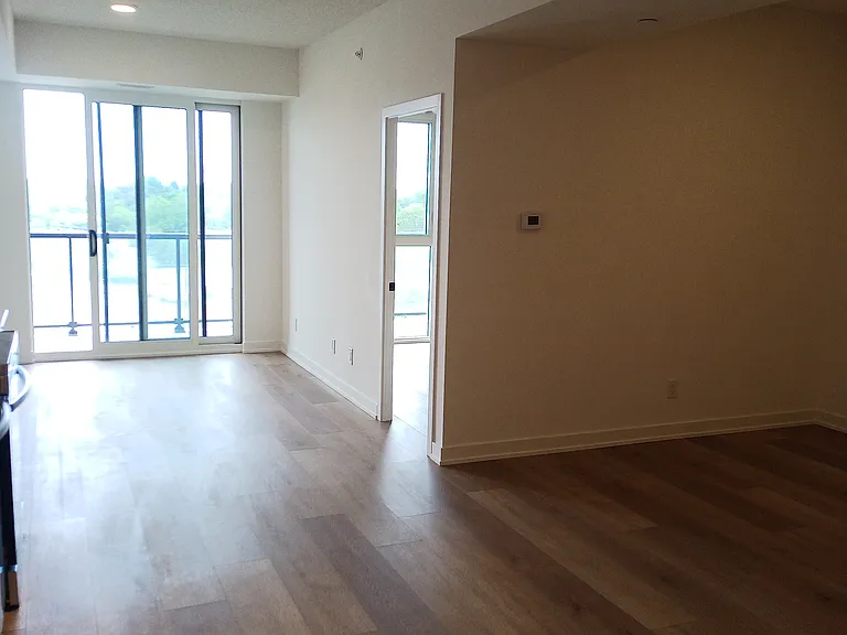 Large Floor to ceiling slider doors ,offering abundance of natural light , Large room area with additional Den .Neutral colors with Oak like wood replica finish floors