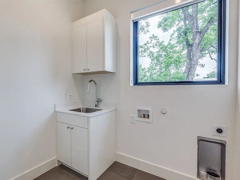 Full size utility room with sink and cabinet storage.