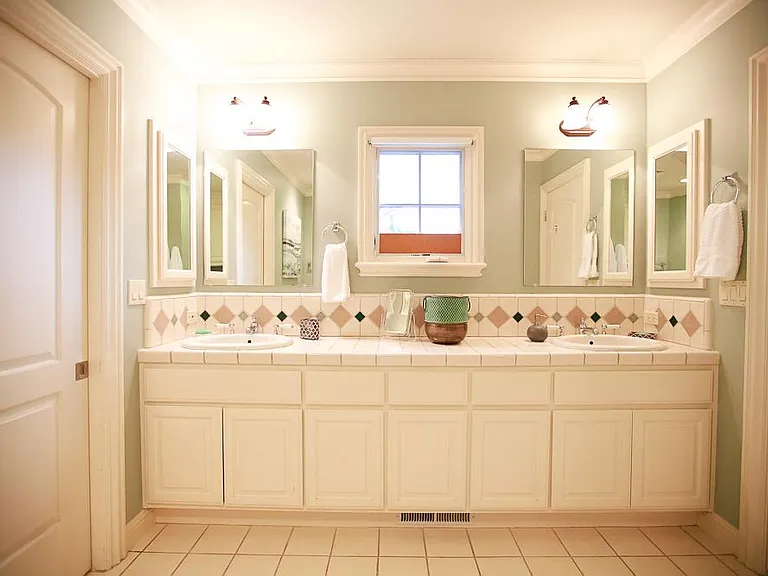 Lots and lots of storage with double sinks, generous counter space, double mirrors on each side, balanced lighting, and a lovely small window with privacy shade overlooking the backyard.