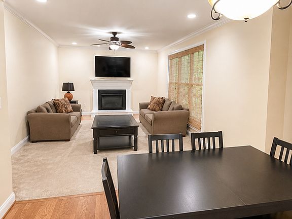 Open-concept main living space with fireplace, mounted TV, crown molding, and flexible dining area off the kitchen _ the heart of this 3,600 sq ft home, perfect for everyday living and entertaining.