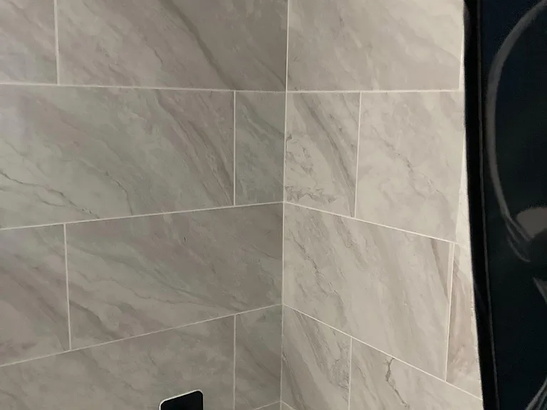 Tiled shower/tub combo with matte-black fixtures and a rain-style showerhead for easy daily use.