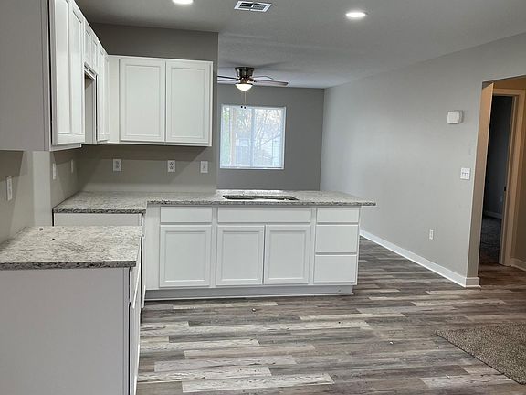 Large open Kitchen / Dinning area features granite countertops with farmhouse sink, white soft-close cabinet doors/drawers _ access to back yard with sliding door . Appliances will be included. (Refrigerator/Stove/Microwave - no dishwasher)