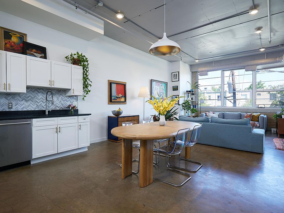 Modern & elegant open-concept living with 13 ft ceilings and original concrete floors
