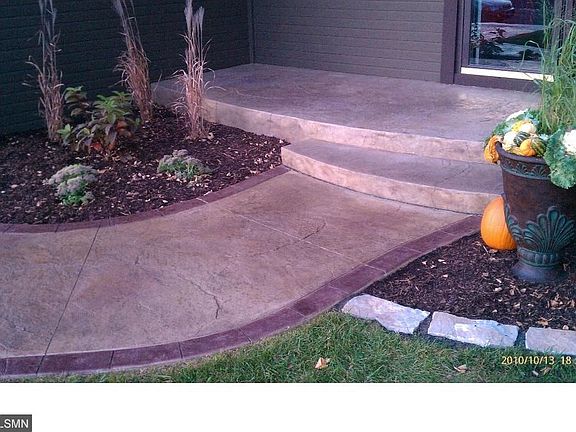 Beautiful stamped concrete entry and front porch.  Stone garden edging around entire house