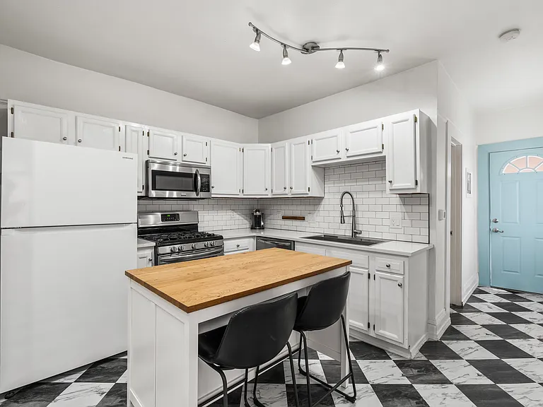 Bright kitchen featuring stainless steel appliances and an oversized island perfect for cooking or entertaining.