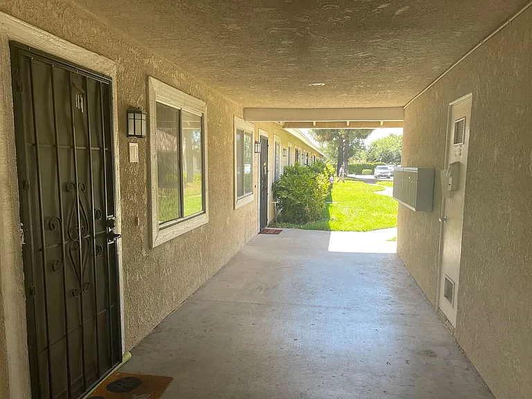 Secured entrance hallway with mailboxes and view to courtyard at Eucalyptus Apartments in Moreno Valley, California.