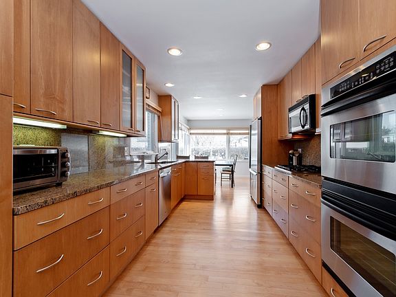 Updated kitchen with stainless appliances, maple cabinets and floor and under cab lights
