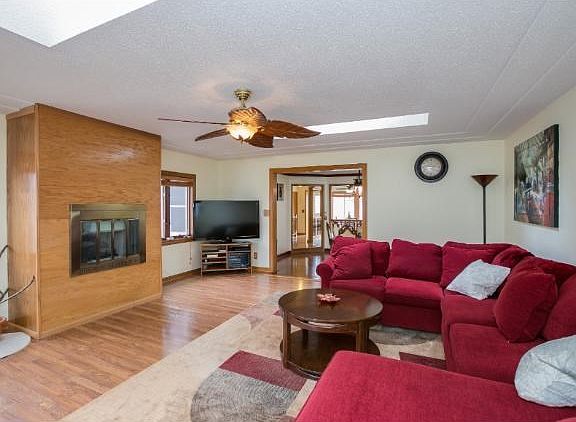Large living room with skylights. Hardwood floor and gas fireplace.