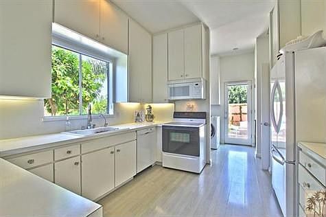 Open bright "White" kitchen-. Access from kitchen to dining area as well as french door to East facing courtyard.