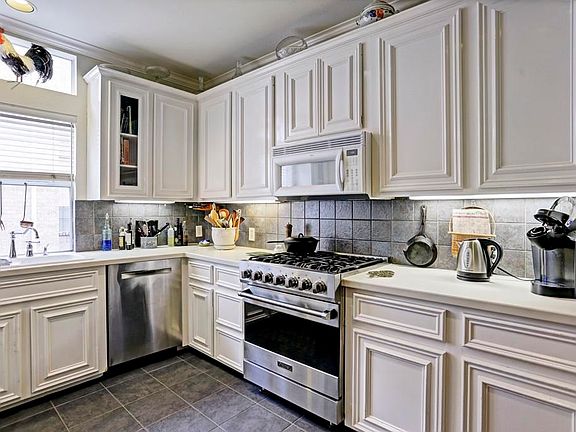 Kitchen with stainless appliances and recent flooring.
