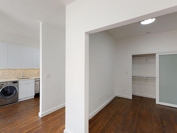 Living area with a wood-like flooring, a closet, and a view of the kitchen