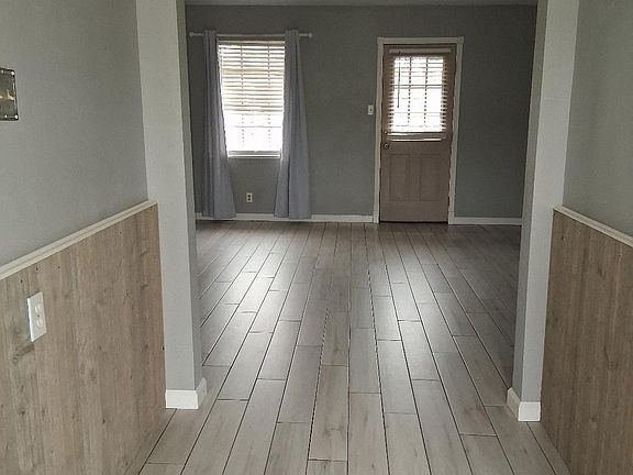 Entry way into the house through the front door. The entry way opens into the open concept living room. The door on the right leads to be backyard.