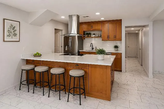 Kitchen features a large island with seating, ample cabinetry, and stainless steel appliances for everyday cooking.