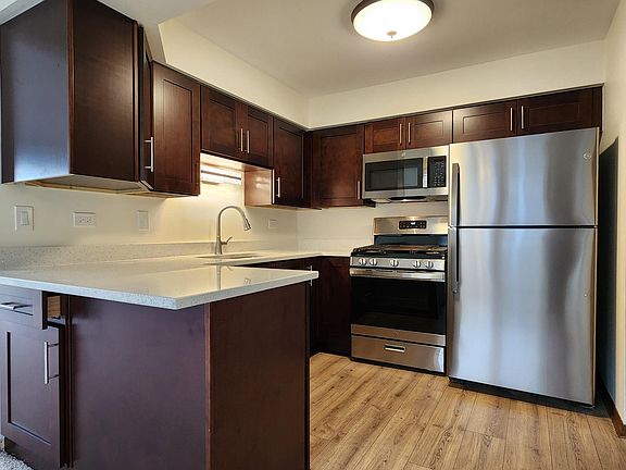 Brand new kitchen includes stainless steel appliances, including microwave, hardwood cabinets, quartz countertops