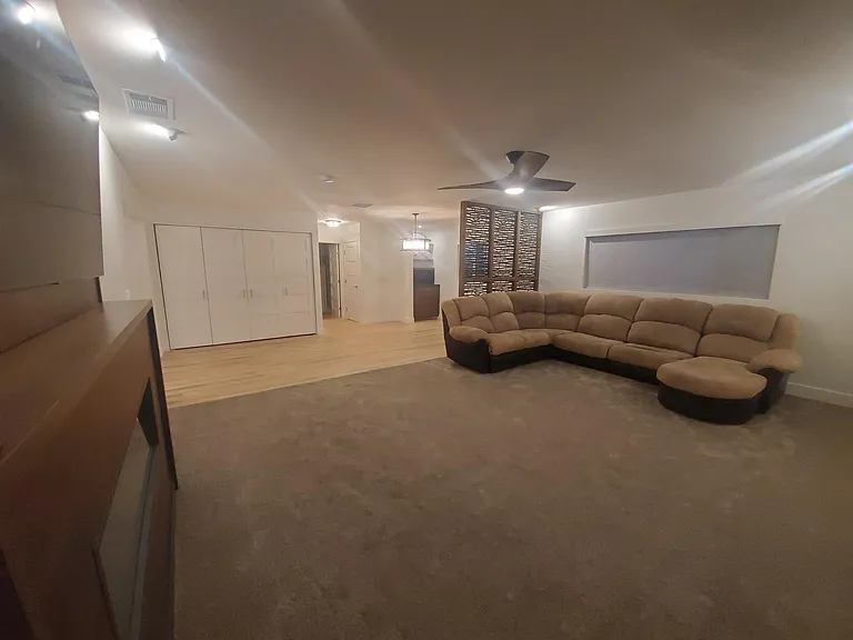 Large living room and dining area with custom room divider, new carpet and flooring, window treatments, throughout home and fireplace.