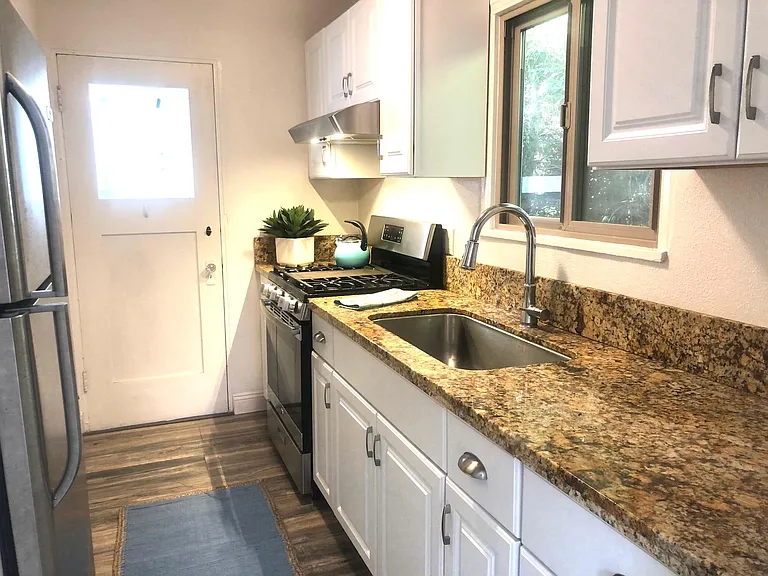 Kitchen with gas range and granite countertops.