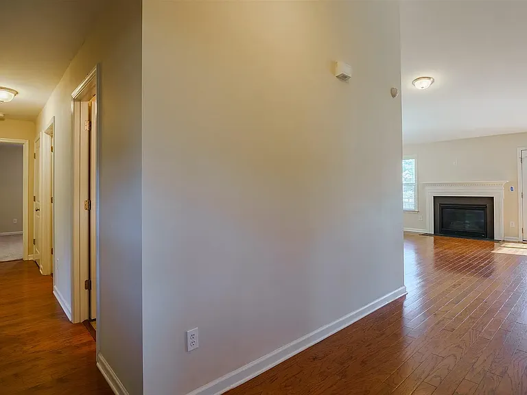 Front door entry looking ahead to family room and down the hall to the left to two of the downstairs bedrooms and full bathroom.