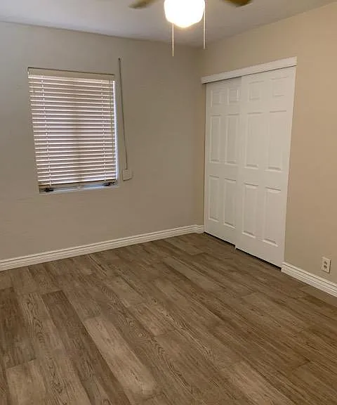 One of the bedrooms--the twin is on the other side of the wall --both with spacious, new closets. Note ceiling fan and rolling shutters on the window for security and light control. There's a large stationary window on left that you can't see.