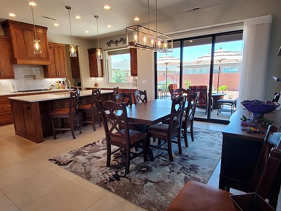 Dining room with sliding door wall of windows to the furnished patio, fire pit, gas grill and maintenance free backyard.