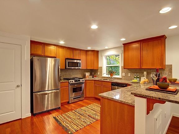 Kitchen features stainless appliances and slab granite counters, including the every loved breakfast