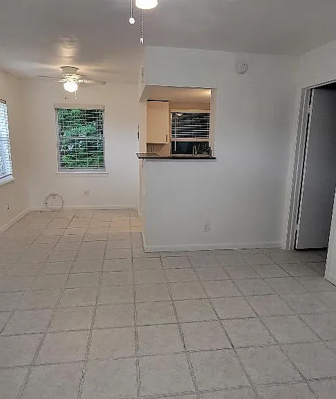 From front door showing kitchen breakfast bar and bedroom door on the right.