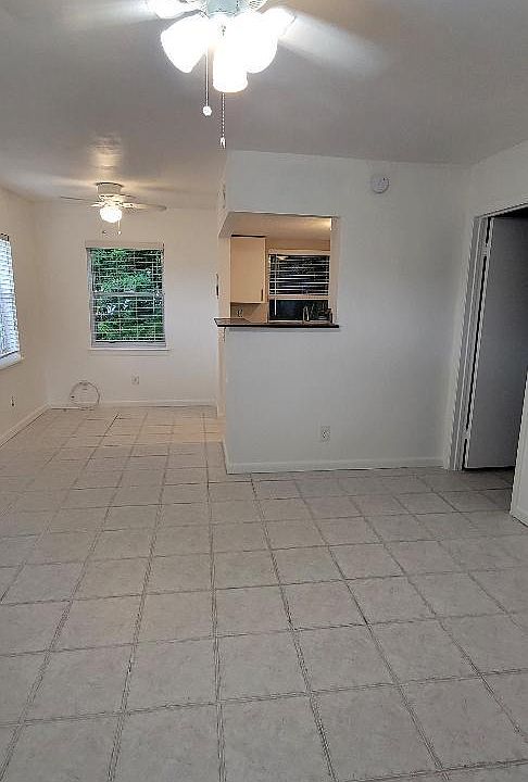 From front door showing kitchen breakfast bar and bedroom door on the right.