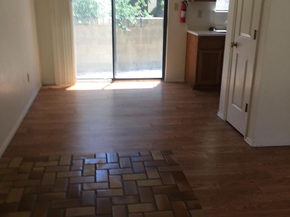 Tiled entry and wood grained flooring throughout. Sliding glass door leads to small yard.