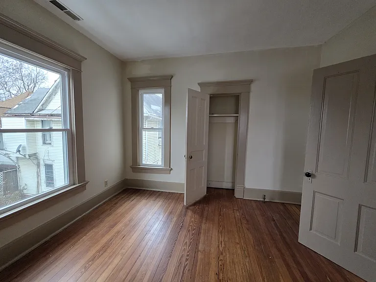 Inside bedroom 3, looking at the windows and closet.
