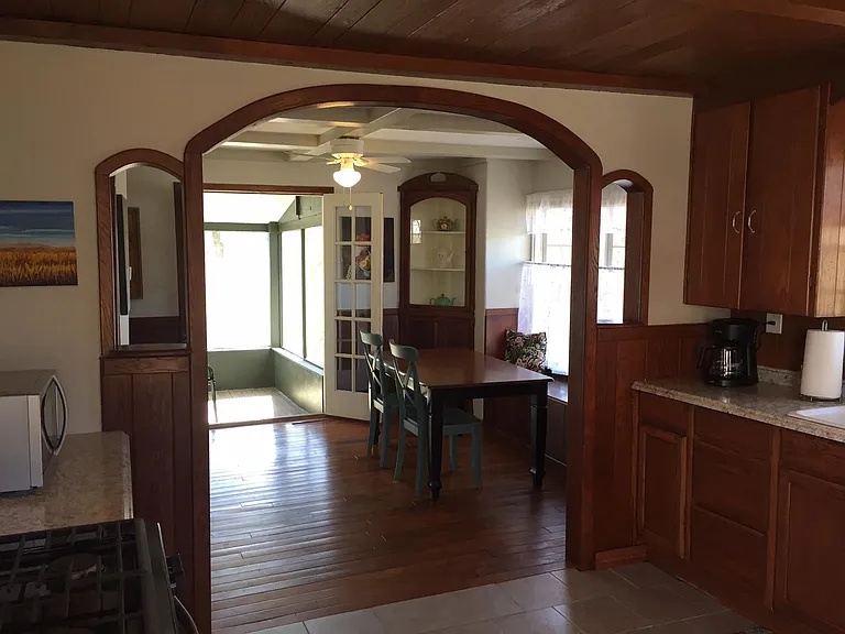 Kitchen looking into the dining room and screened porch.