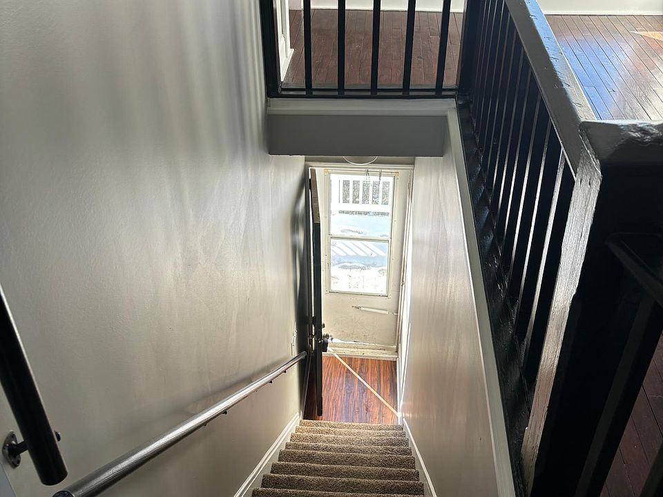 Looking down the stairs to entry door and porch