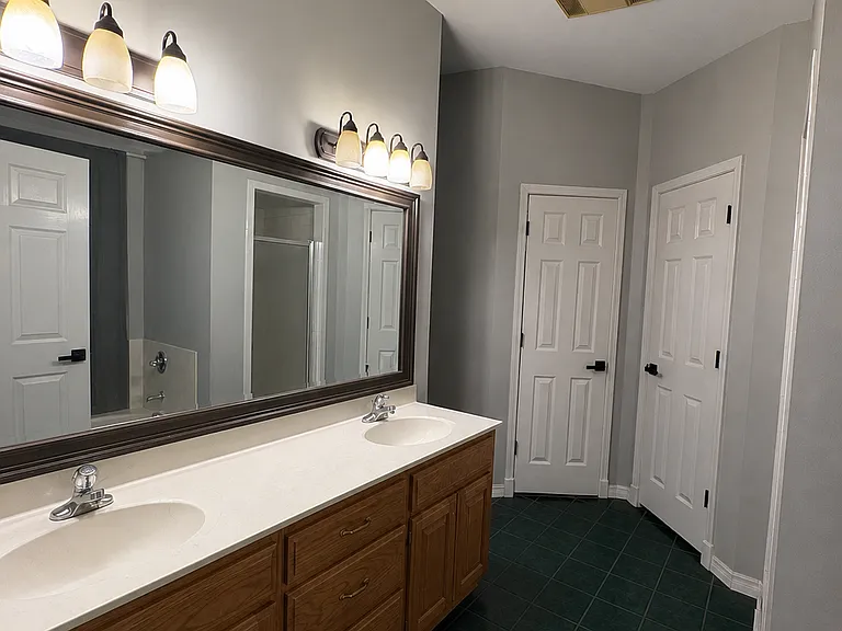 Primary bathroom with dual closets, walk in shower, and jetted tub