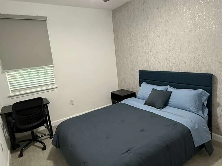 Second bedroom. Includes blackout blind, queen bed with matress, nightstand, and desk with chair.