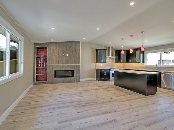 Open Concept living, kitchen and dining with fireplace, vaulted ceilings and beautiful wide plank flooring and flooded with light