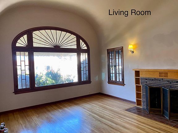 Bright, spacious living room with 10 ft domed ceiling and hardwood floor