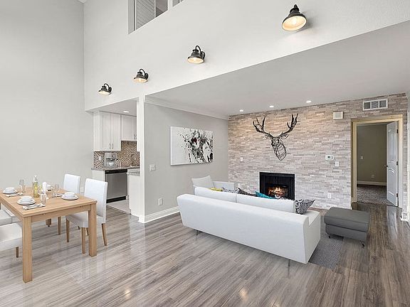 Living room with decorative stone wall and view of loft overhead.